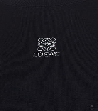 Close-up of black knitted blouse with anagram - CALIENTE